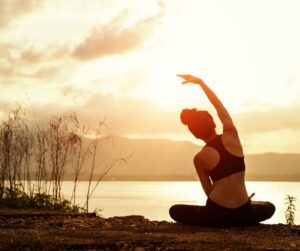 woman in yoga pants doing yoga by lake